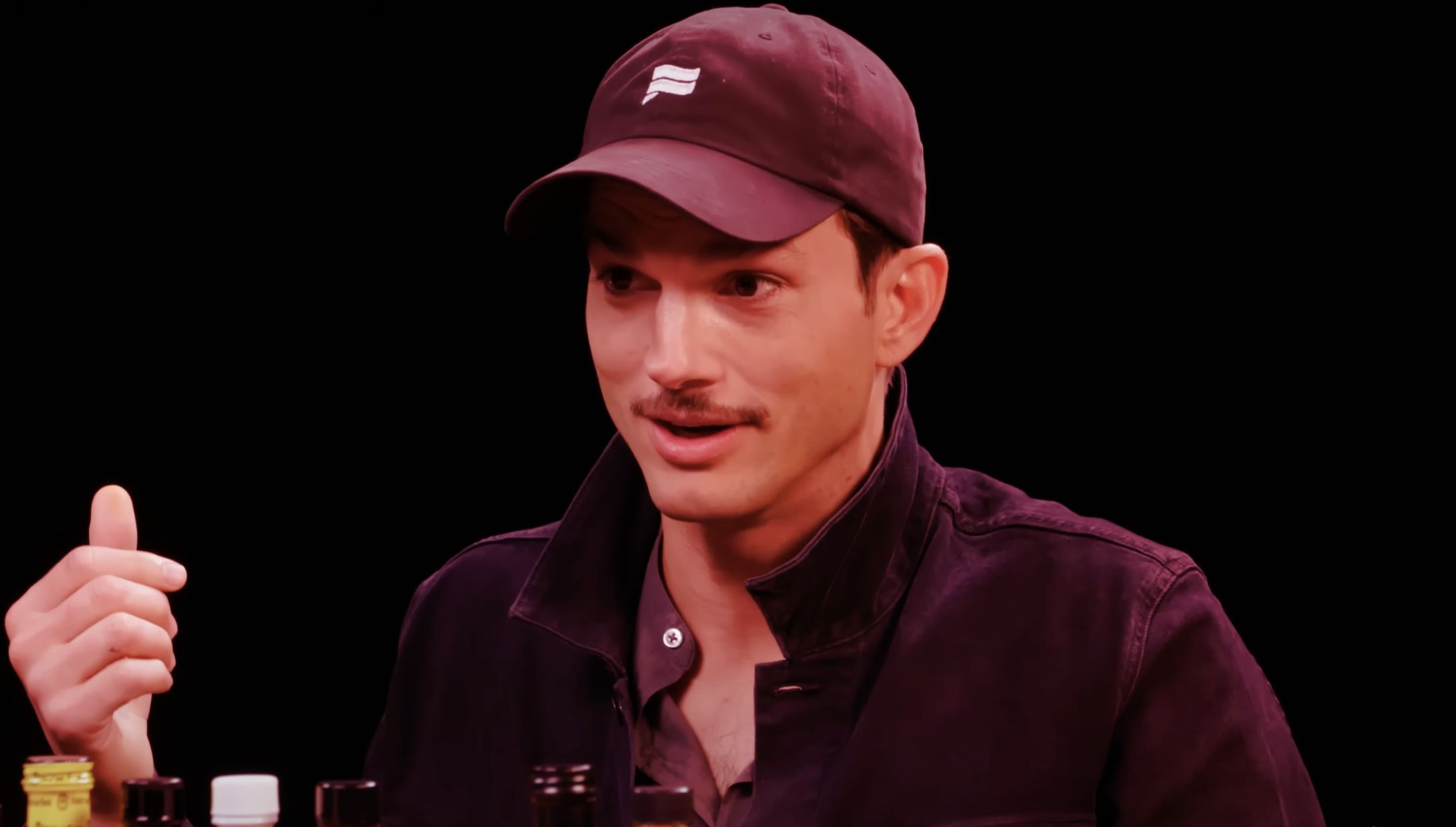 Ashton Kutcher during his Hot Ones interview in September 2019 (Image via Youtube/@First We Feast)