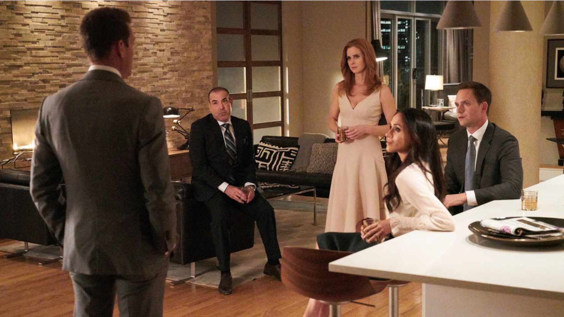 Characters Mike Ross, Rachel Zane, Donna Paulson, and Louis Litt gathering around Harvey in a still from Suits | Image Source: Netflix