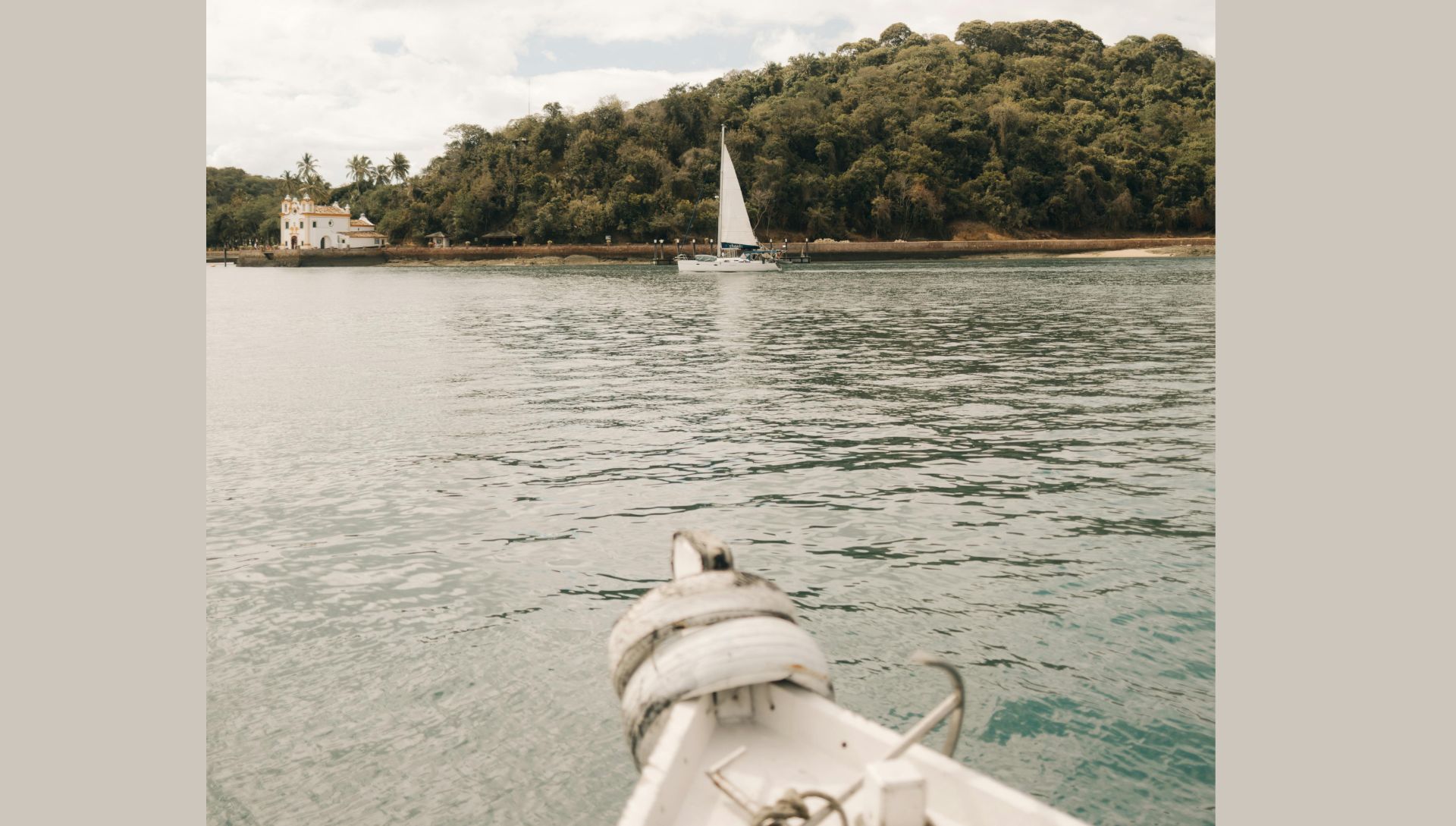 Scenic View of Sailboat Near Lush Island (Image via Pexels) 