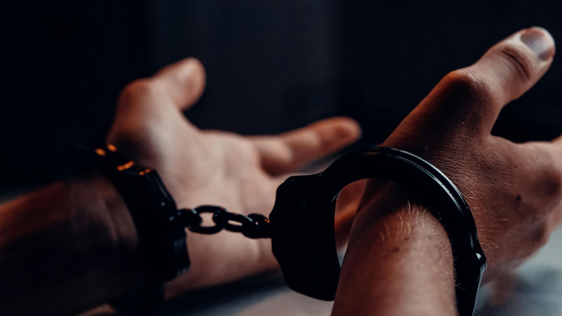 A handcuffed man (Image via Pexels/Kindel Media)