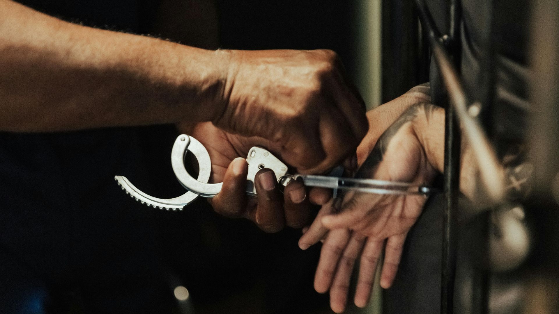 A person getting handcuffed (Image via Pexels/Ron Lach)