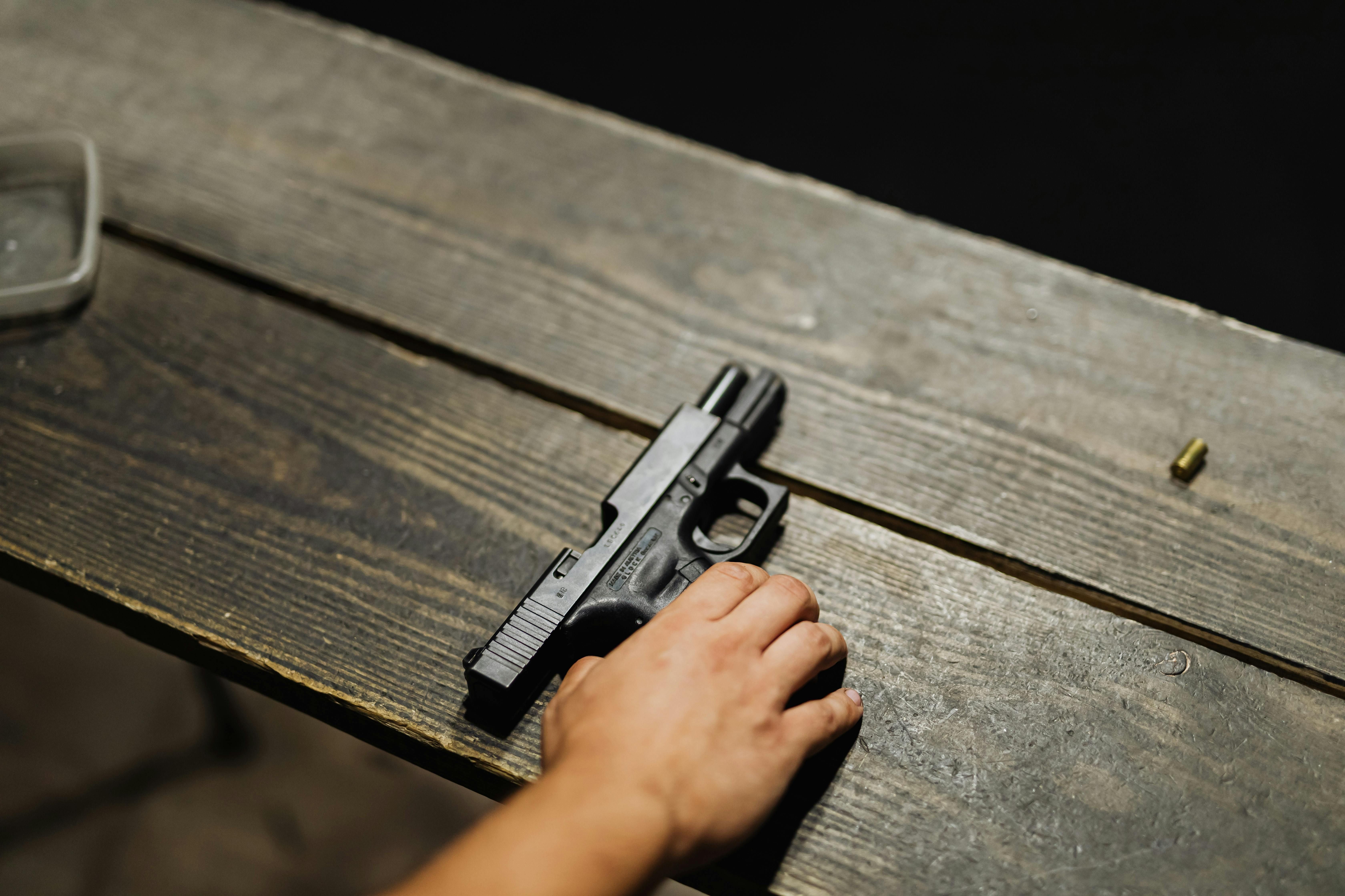 Hand of a Person Holding Black Semi Automatic Pistol