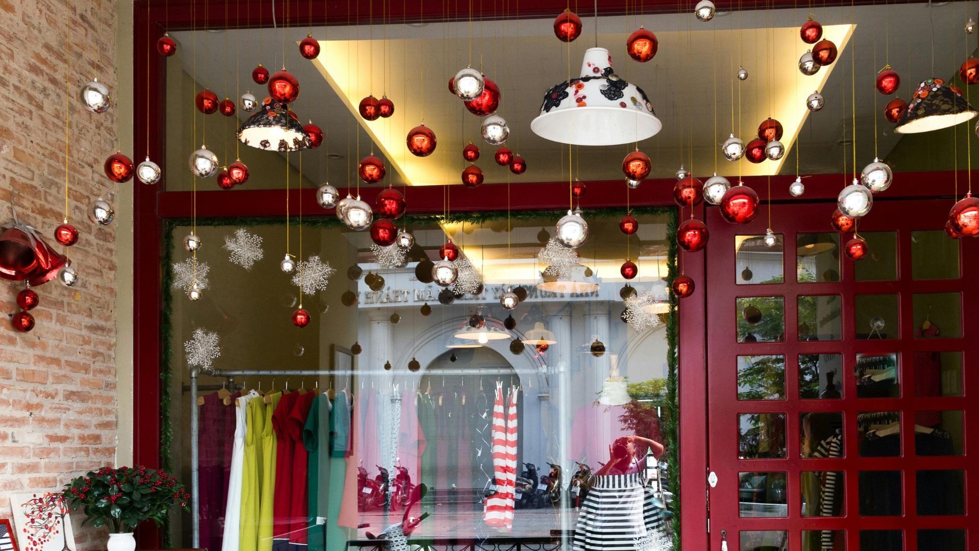 A rack of clothes in a shop with holiday decorations (Image via Pexels / Quang Nguyen Vinh)