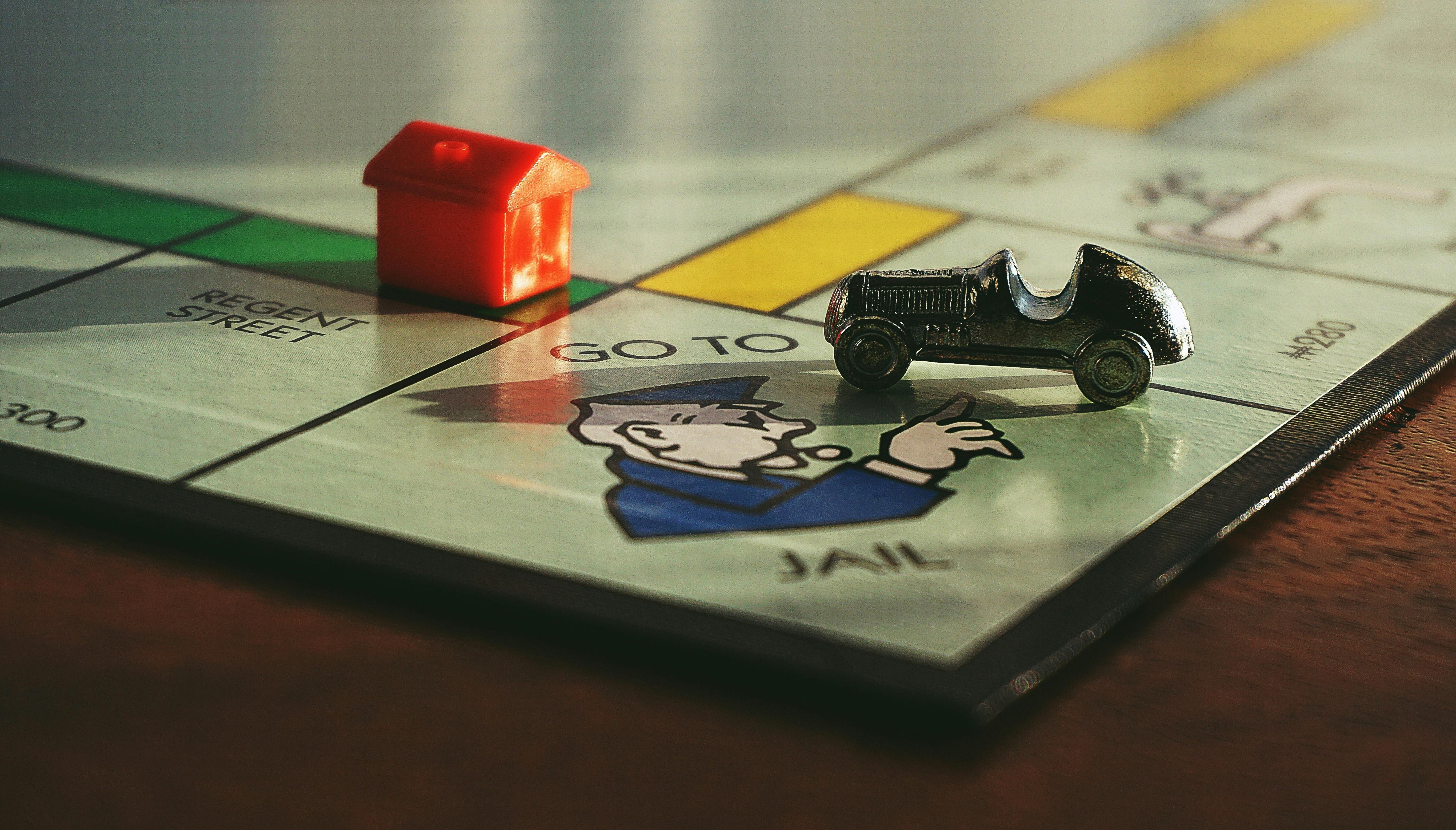 Miniature toy car on Monopoly board game (Image via Pexels / Suzy Hazelwood)