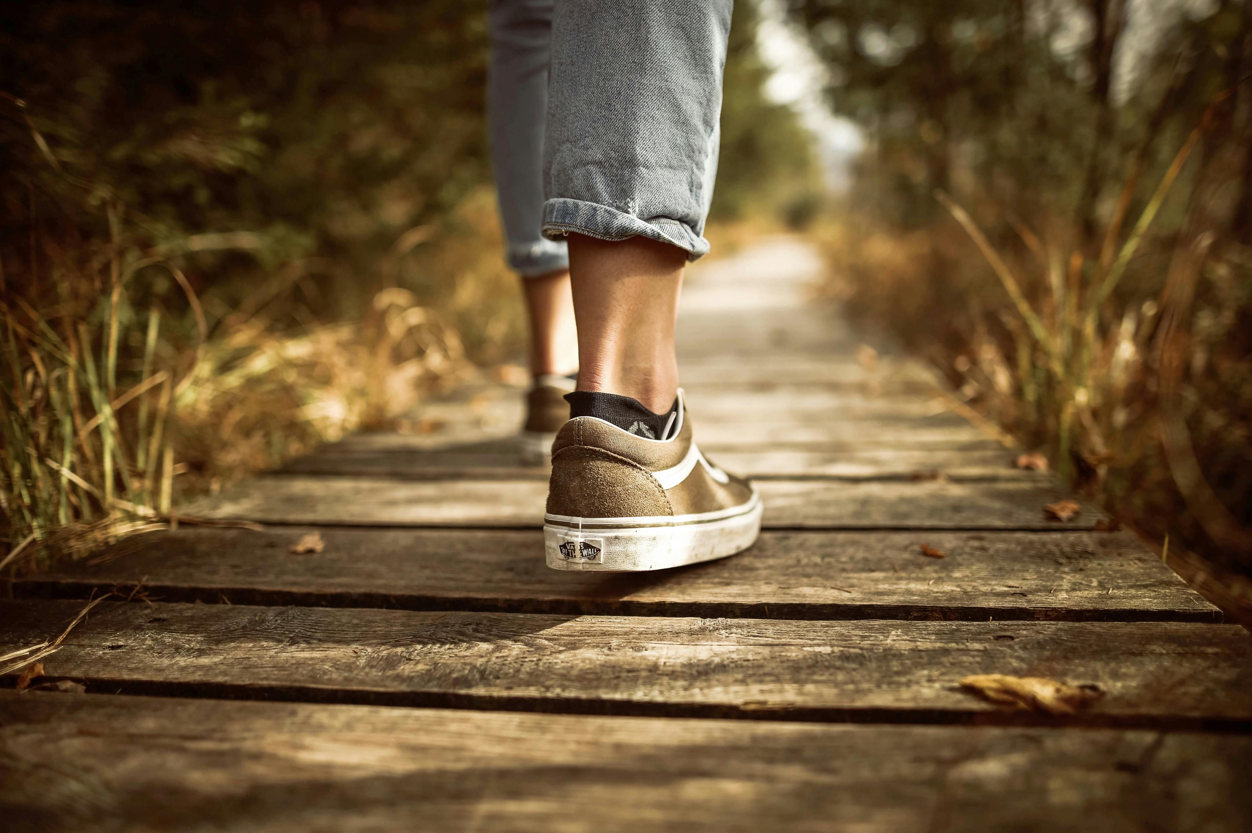 Person Stands on Brown Pathway (Image via Pexels)