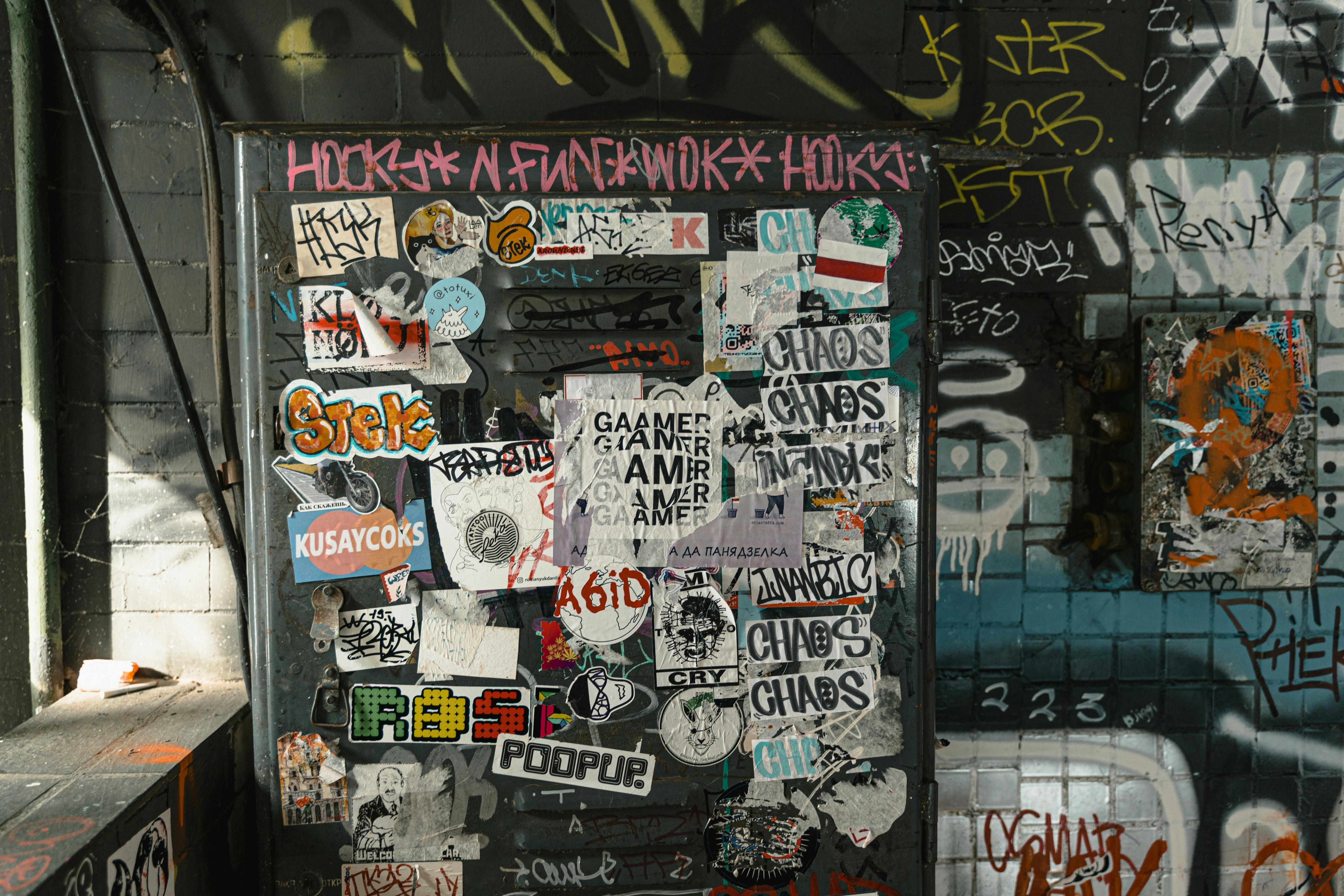 Close Up Photo of Wall with Graffiti and Posters