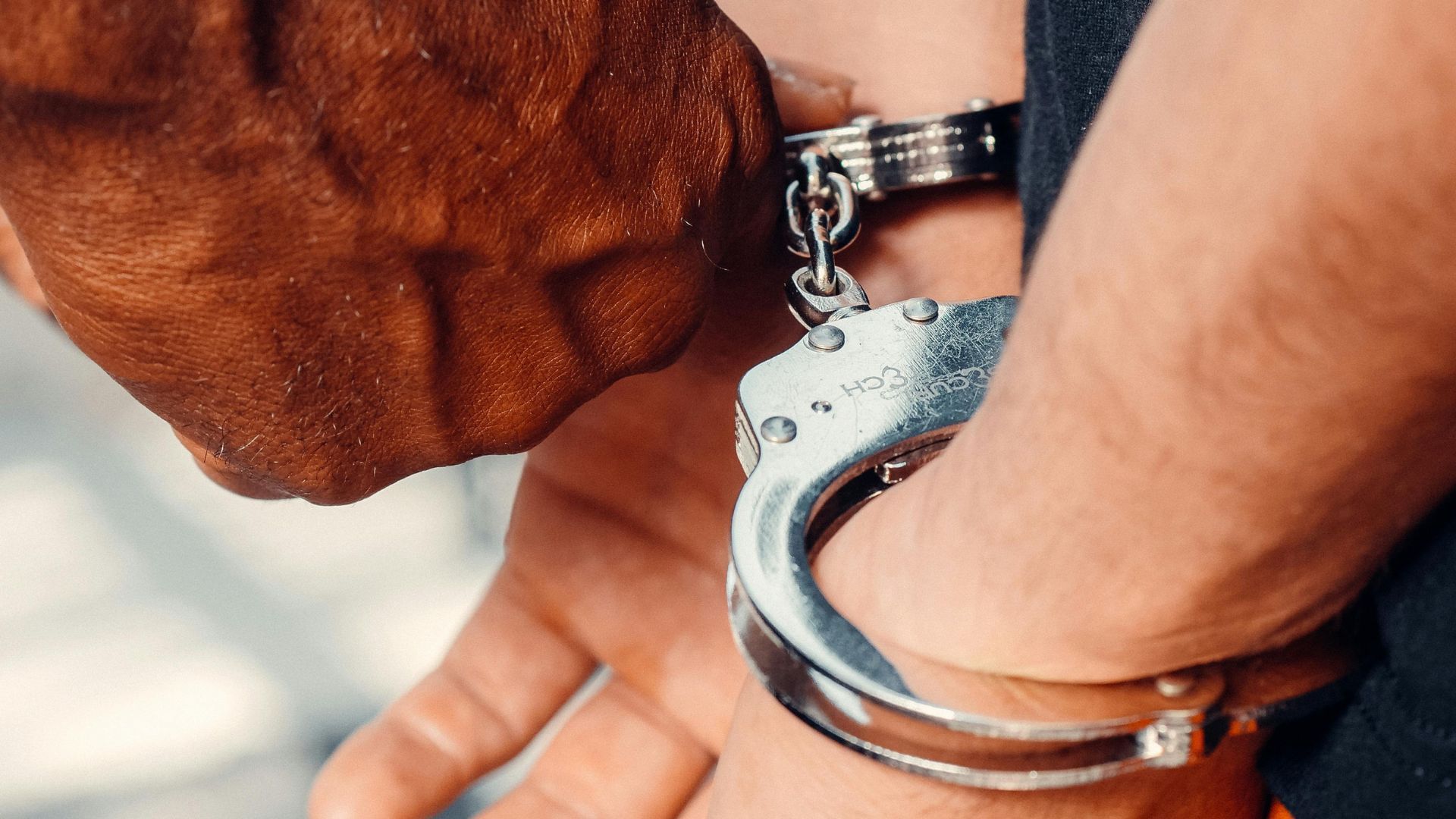 A handcuffed person (Image via Pexels/Kindel Media)