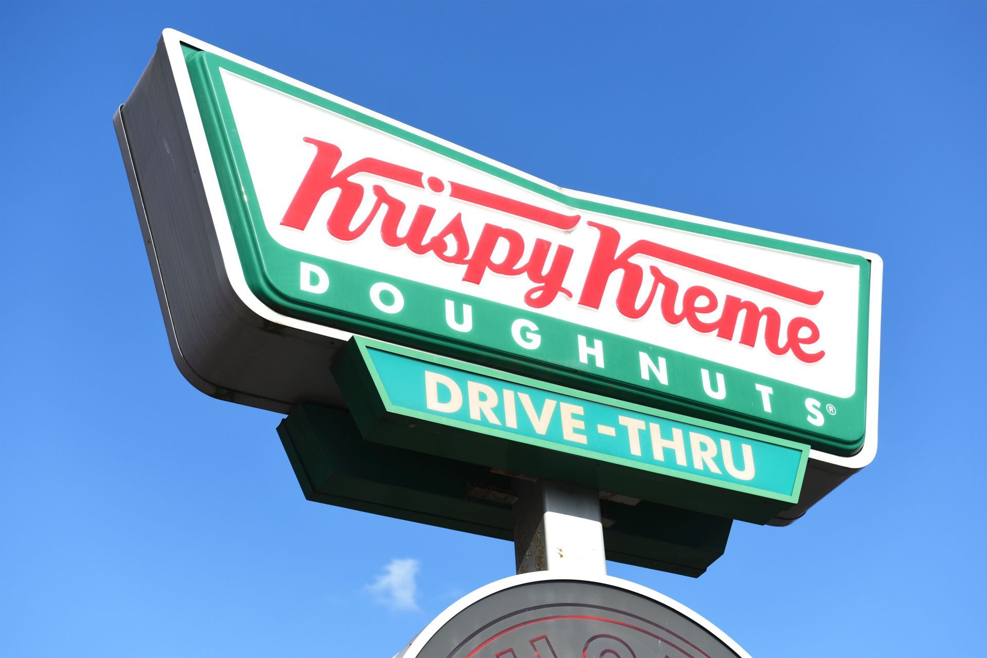 Krispy Kreme Doughnuts store sign on building exterior, store frontage - Source: Getty