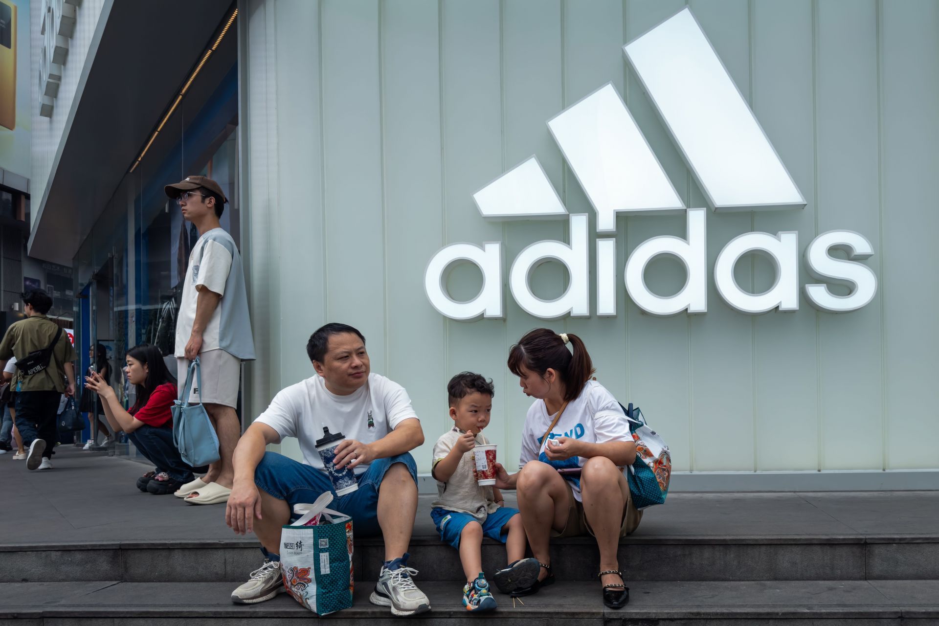 Family Resting Outside Adidas Store in Chengdu - Source: Getty