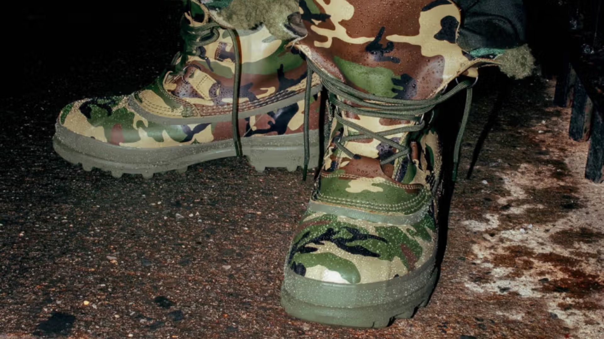 The camo version of the winter boots combines street style with a practical winter design. The shiny upper is dressed in a camo design featuring swaths of green, black, and cream (Image via Supreme)