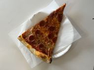 A slice of pizza (Image via Getty)