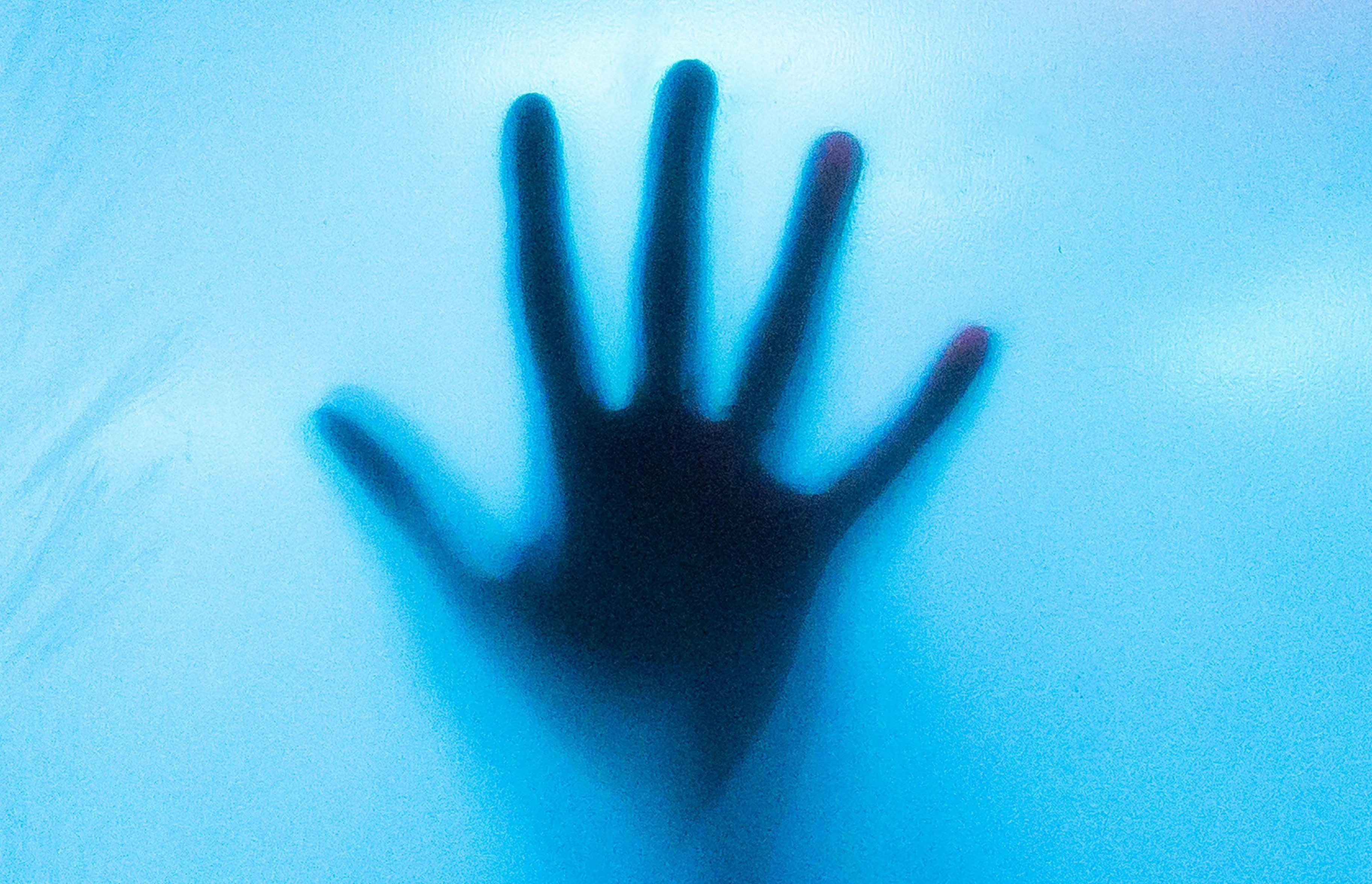 A Hand on a Blue Translucent Object (Image via Pexels) 