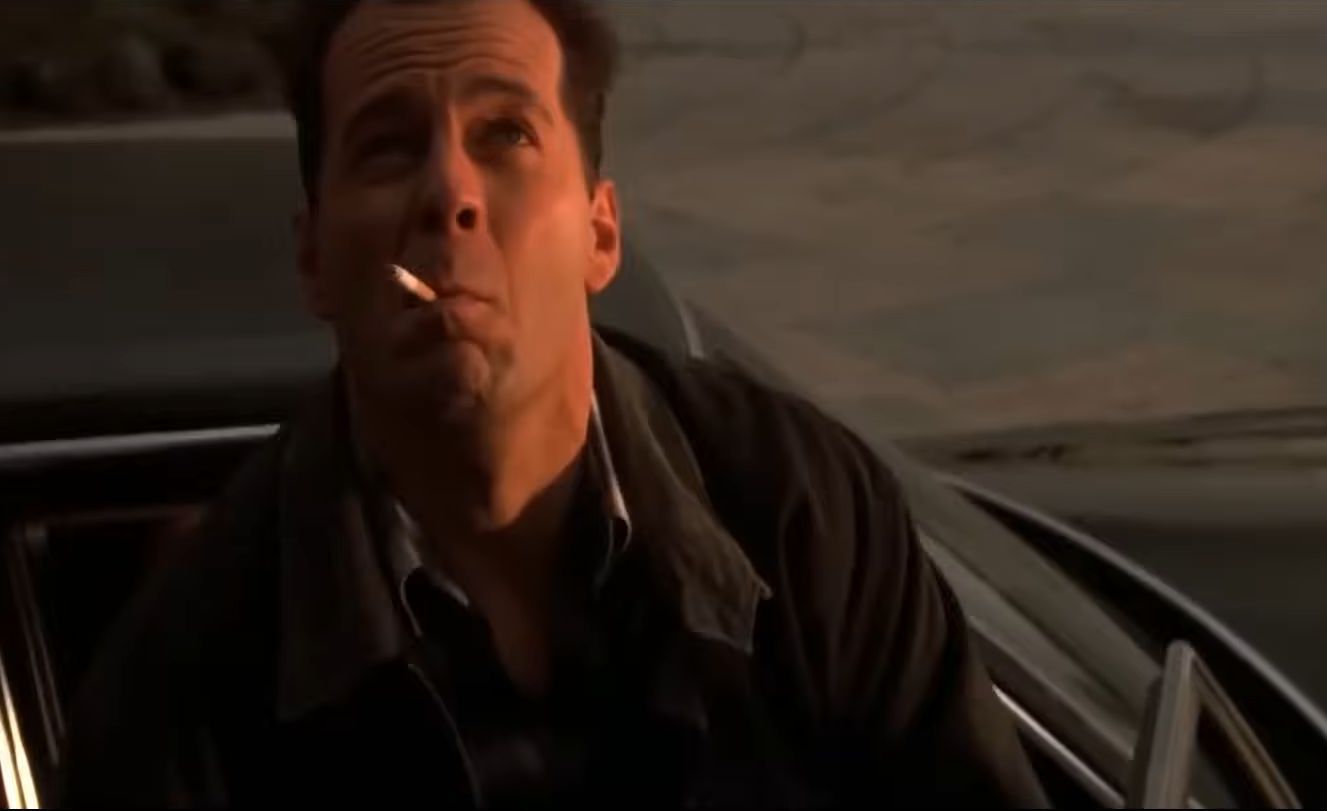 John McClane is seen smoking while looking up