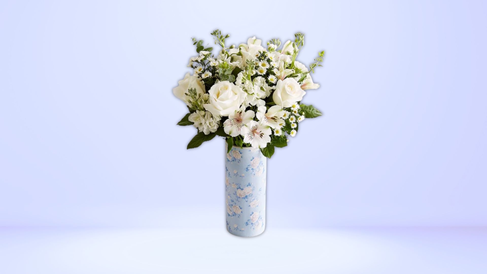 The arrangement features a mixture of white roses, Santini poms, Peruvian lilies (Image via 1-800-Flowers)