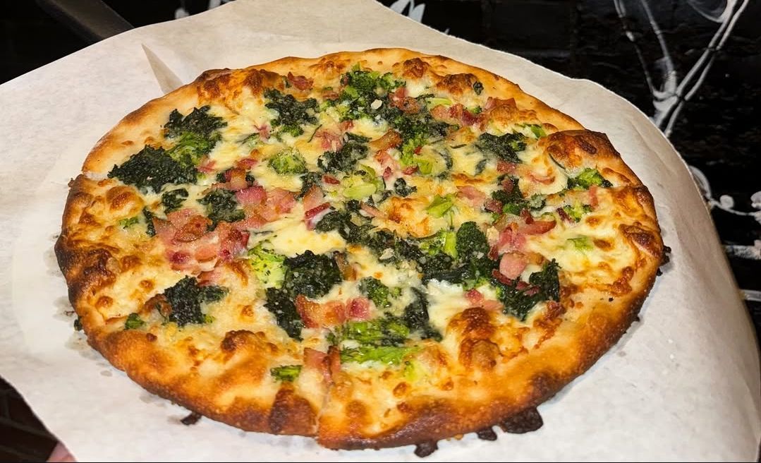 White pie with bacon, broccoli, spinach, and garlic from Joey Garlics. (Image via Instagram/@joey_garlics)