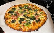 White pie with bacon, broccoli, spinach, and garlic from Joey Garlics. (Image via Instagram/@joey_garlics)