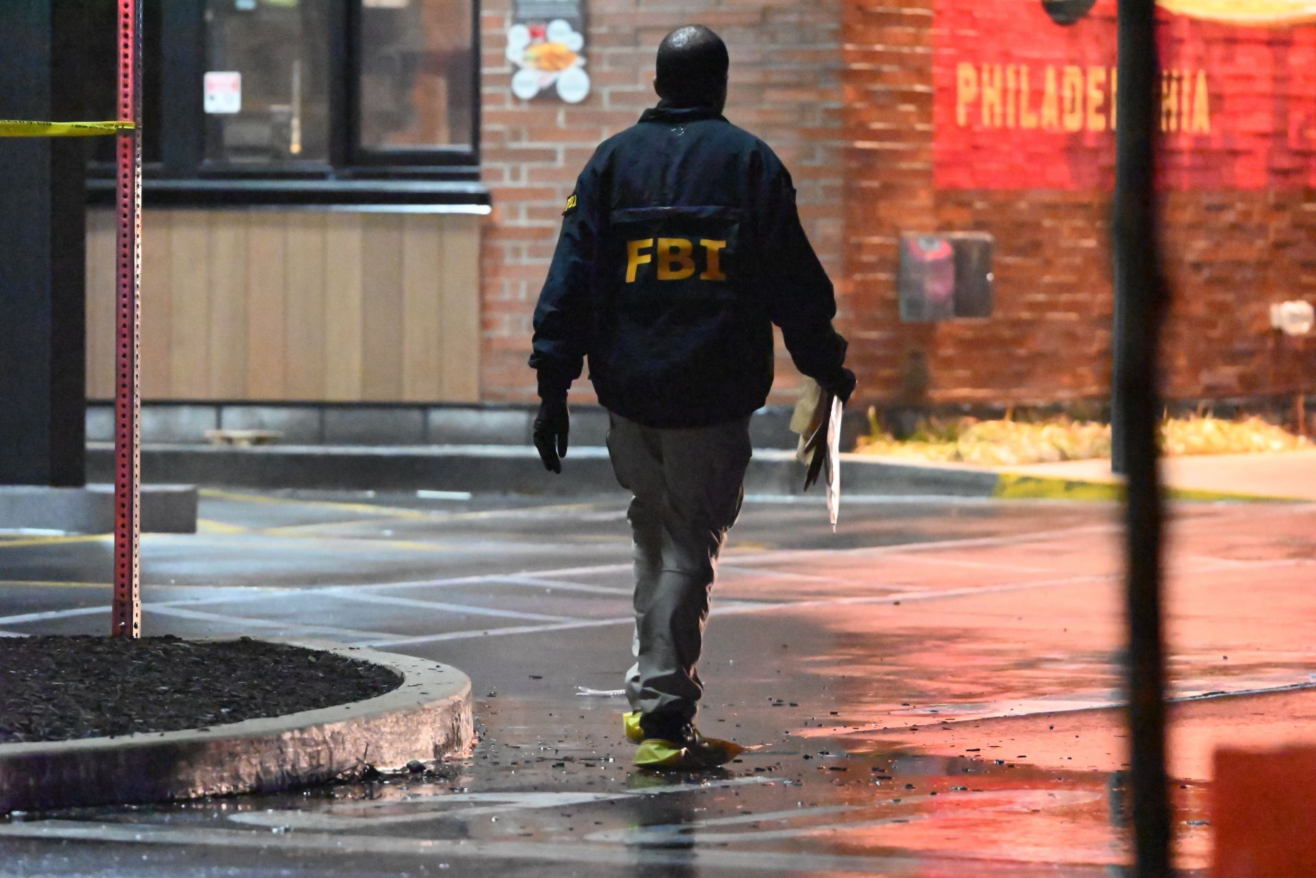 An FBI agent collects evidence and surveys the damage at the site of destruction (Image via Getty)