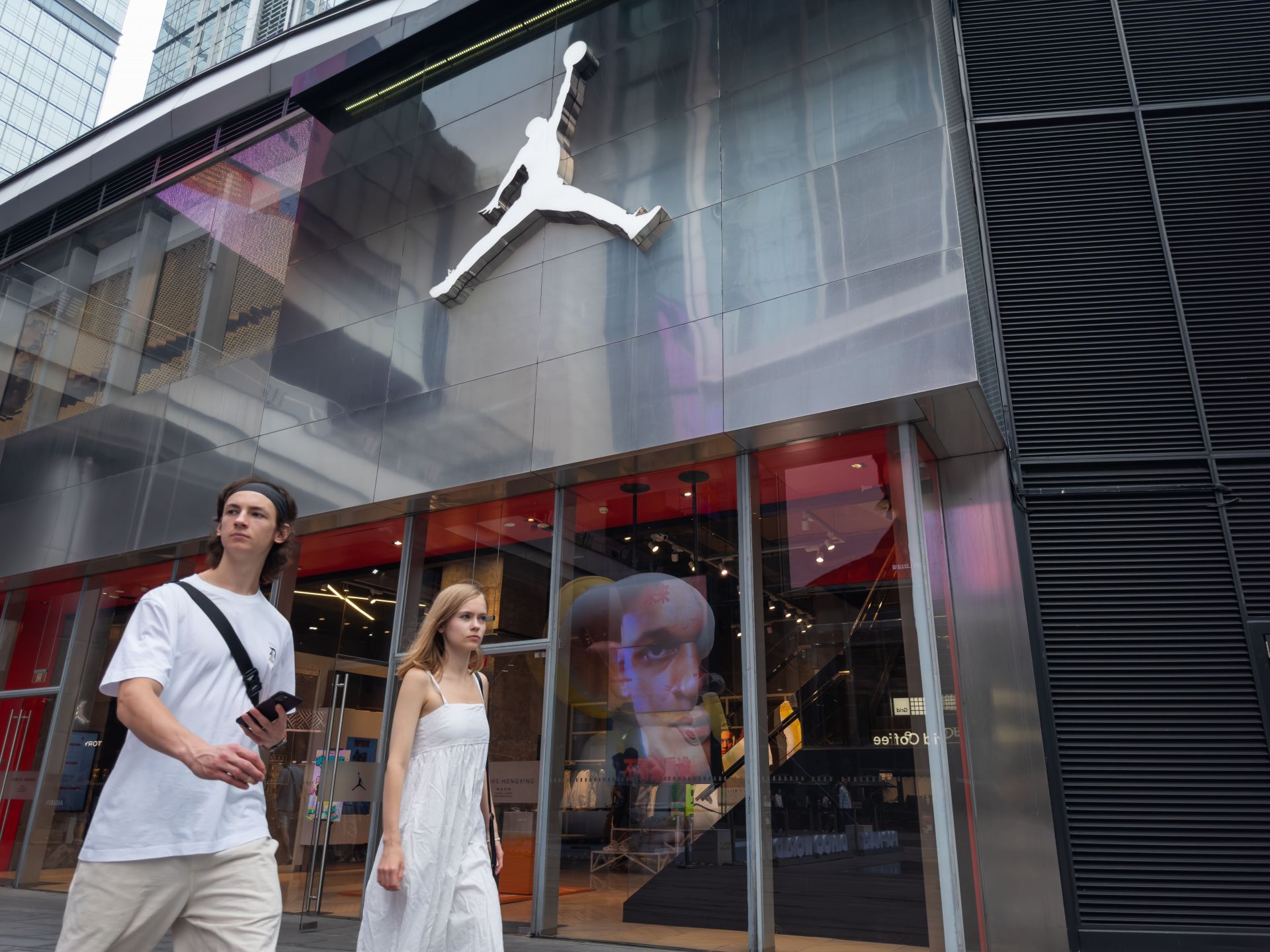 Couple Walks Past Jordan Brand Storefront in Chengdu - Source: Getty