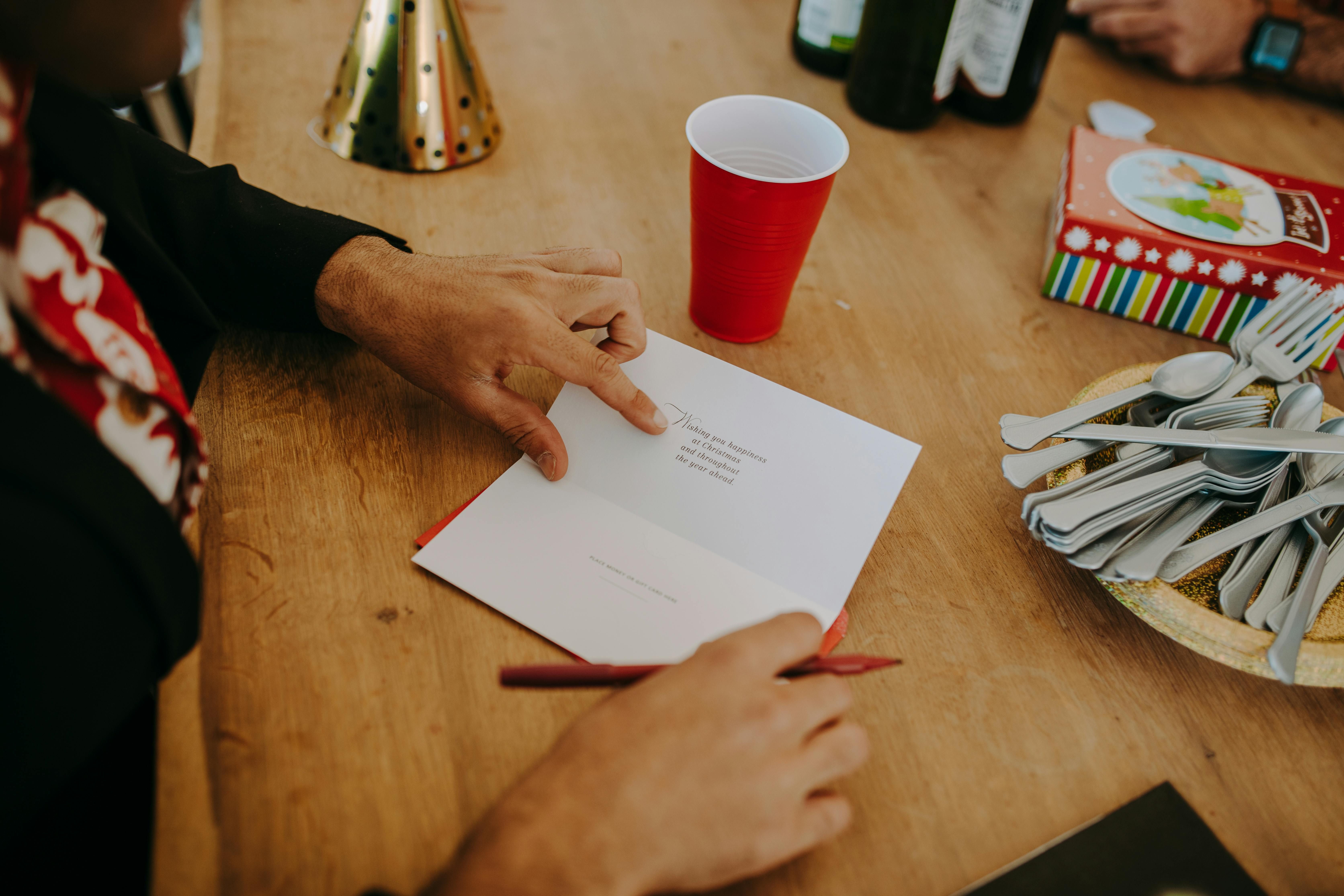 Person holding a Christmas Card (Image via Pexels)