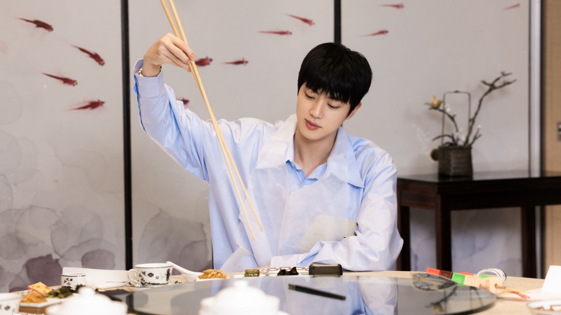 Scene from Run Jin - Jin eating with long chopsticks in one of the program&#039;s challenges | Source: Weverse