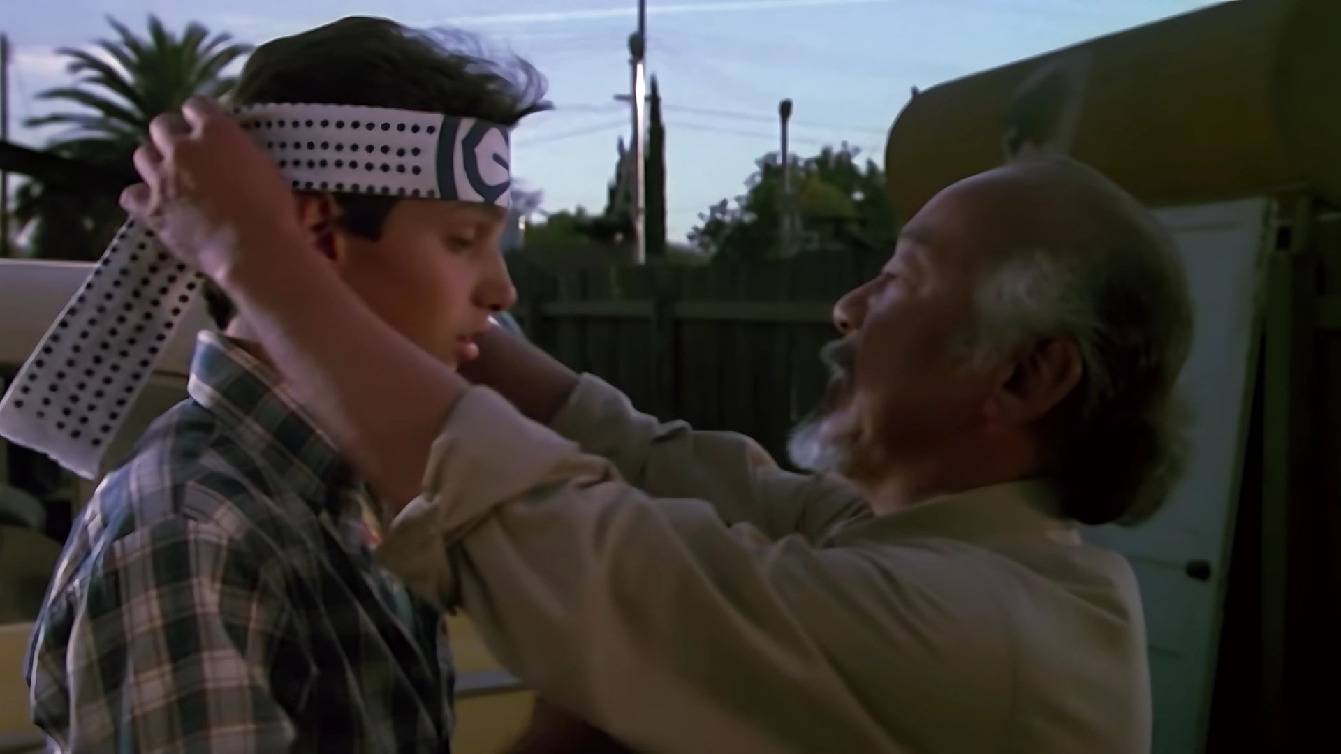 Mr. Miyagi tying a bandana around Daniel LaRusso