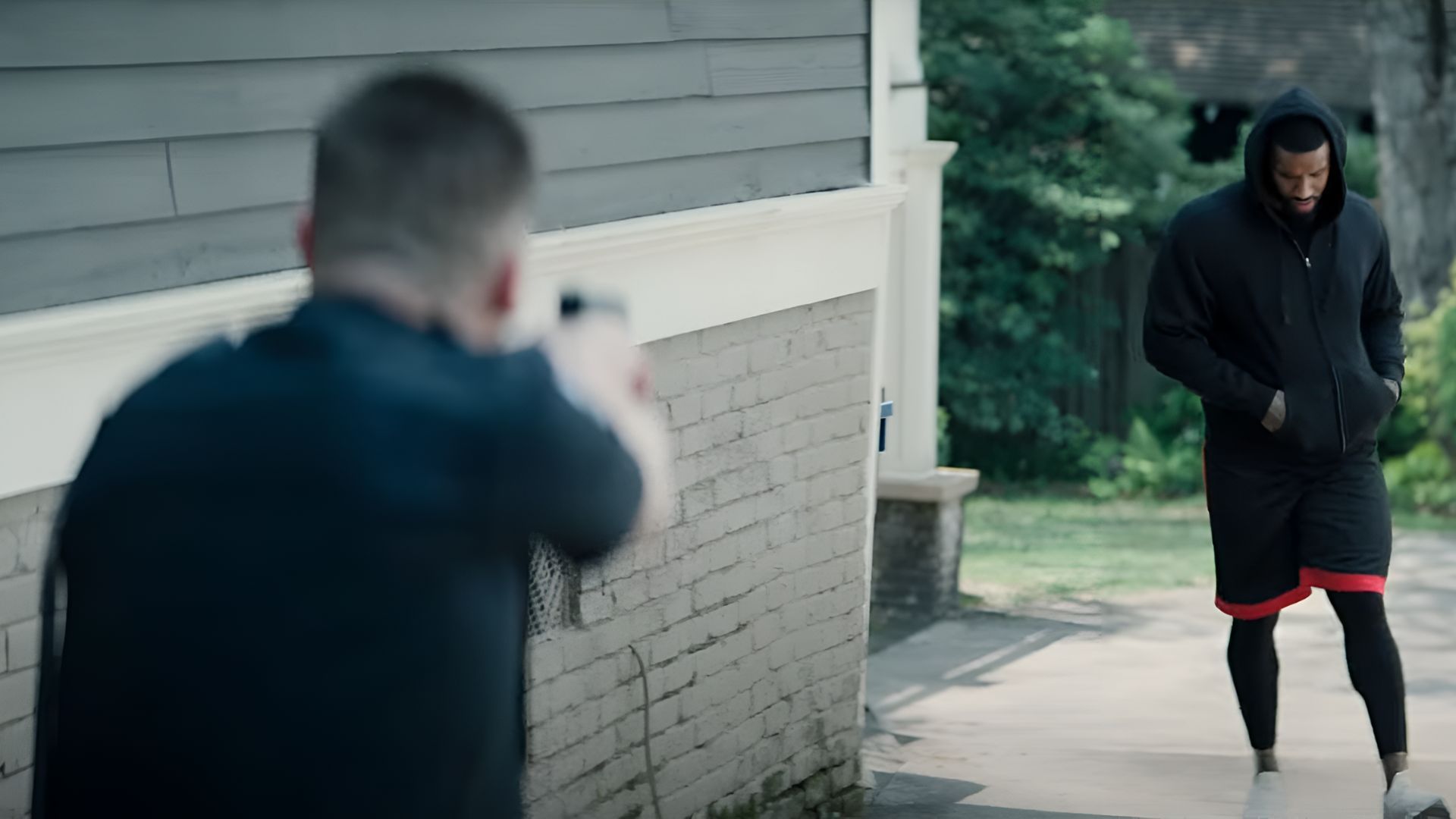 A man walking and a police officer brings out a gun on him