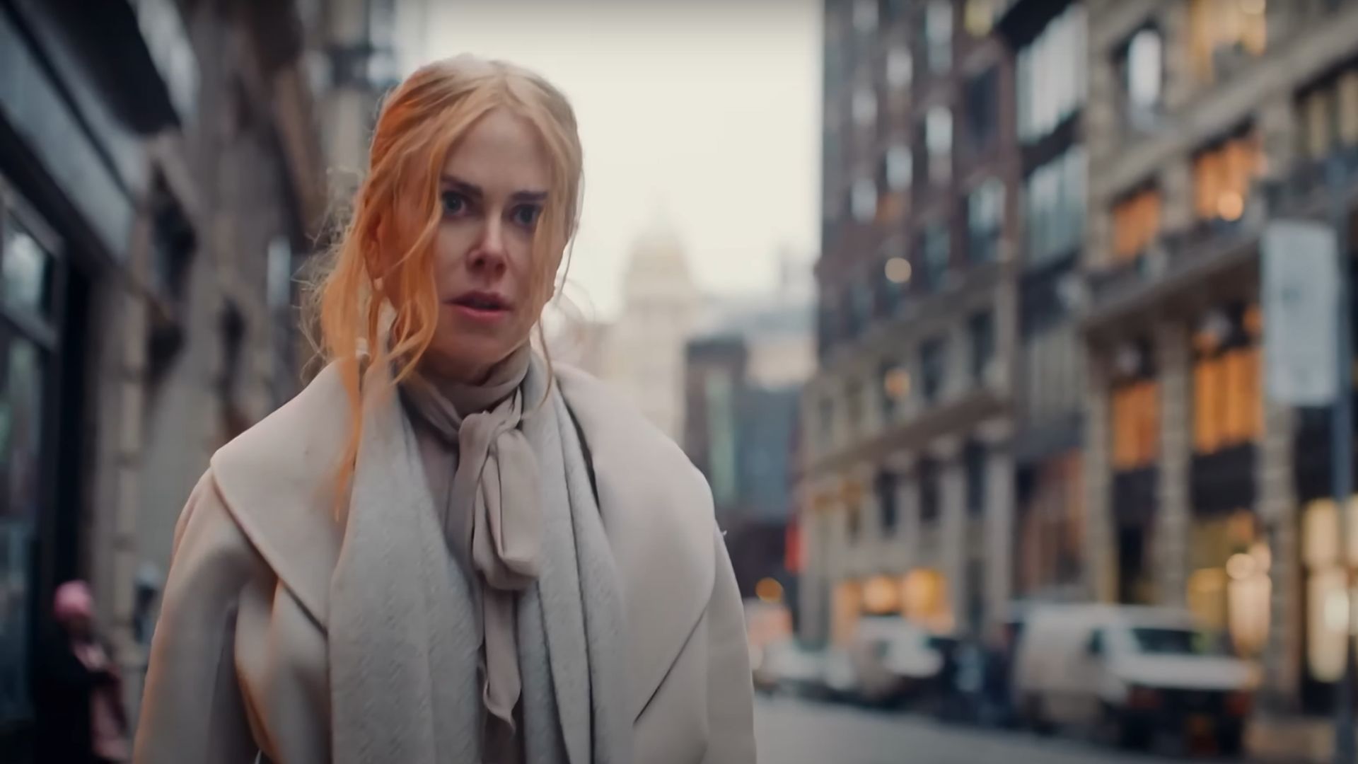 Nicole Kidman looks at something in surprise in an external urban setting
