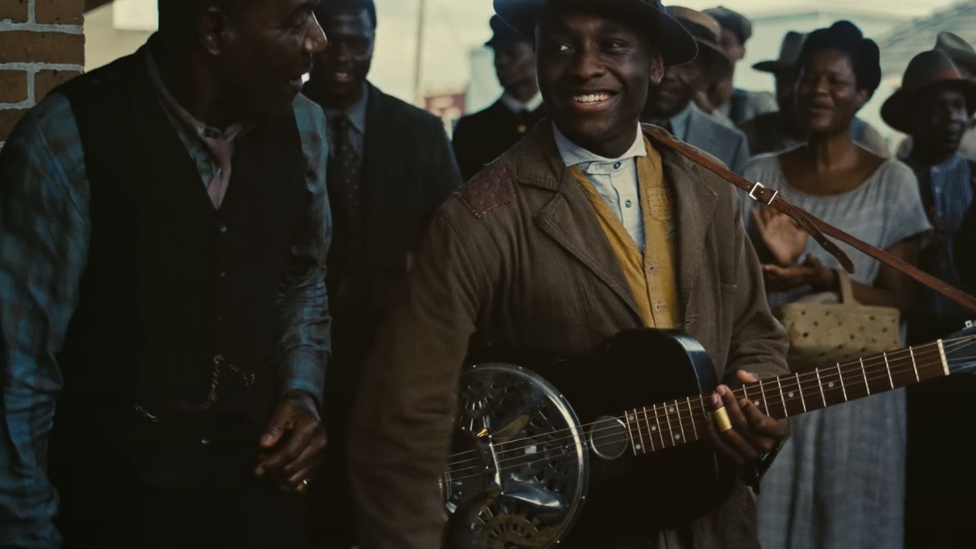 Sammie plays guitar amid a crowd of people