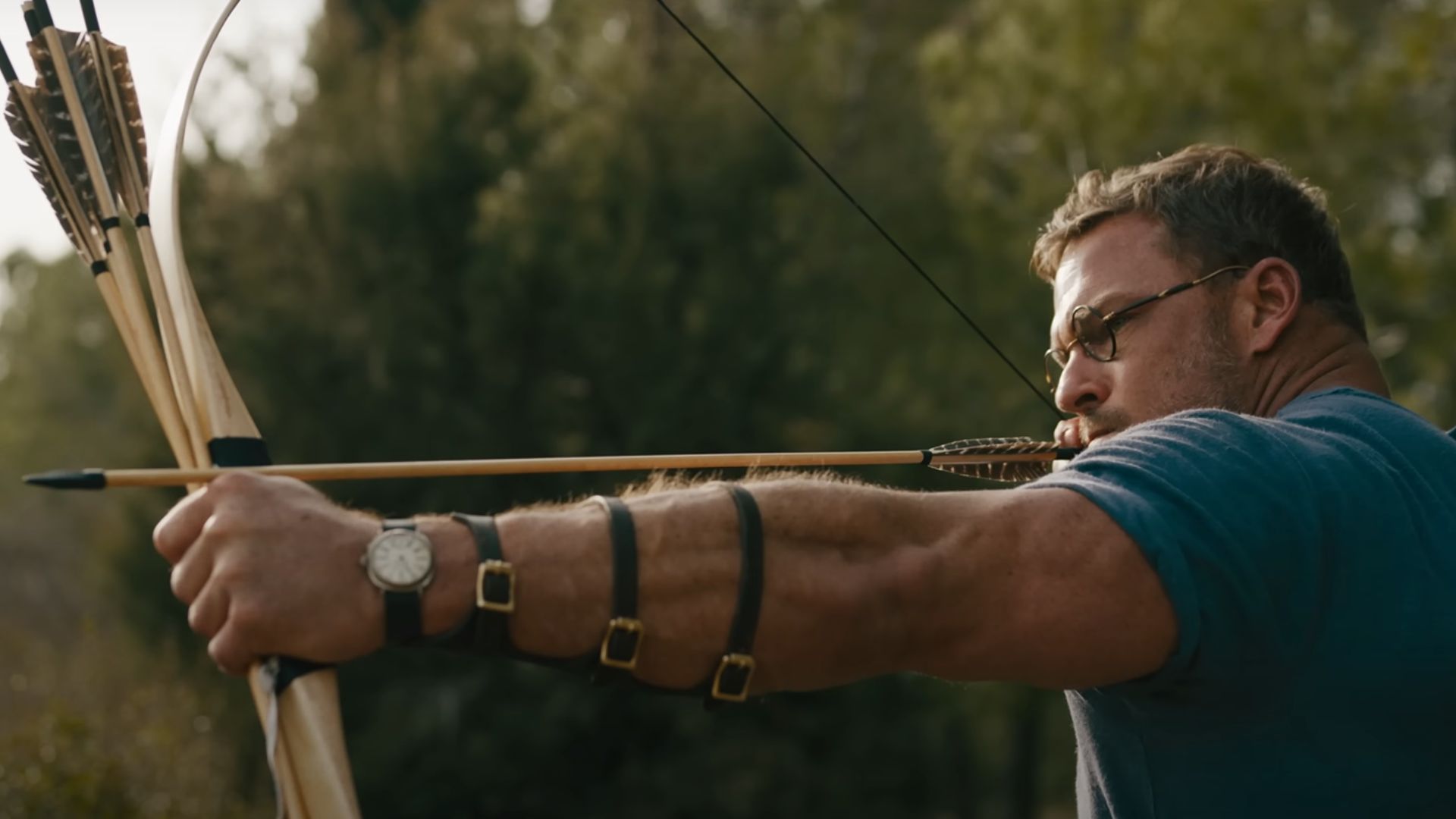 Alan Ritchson about to shoot an arrow from a bow