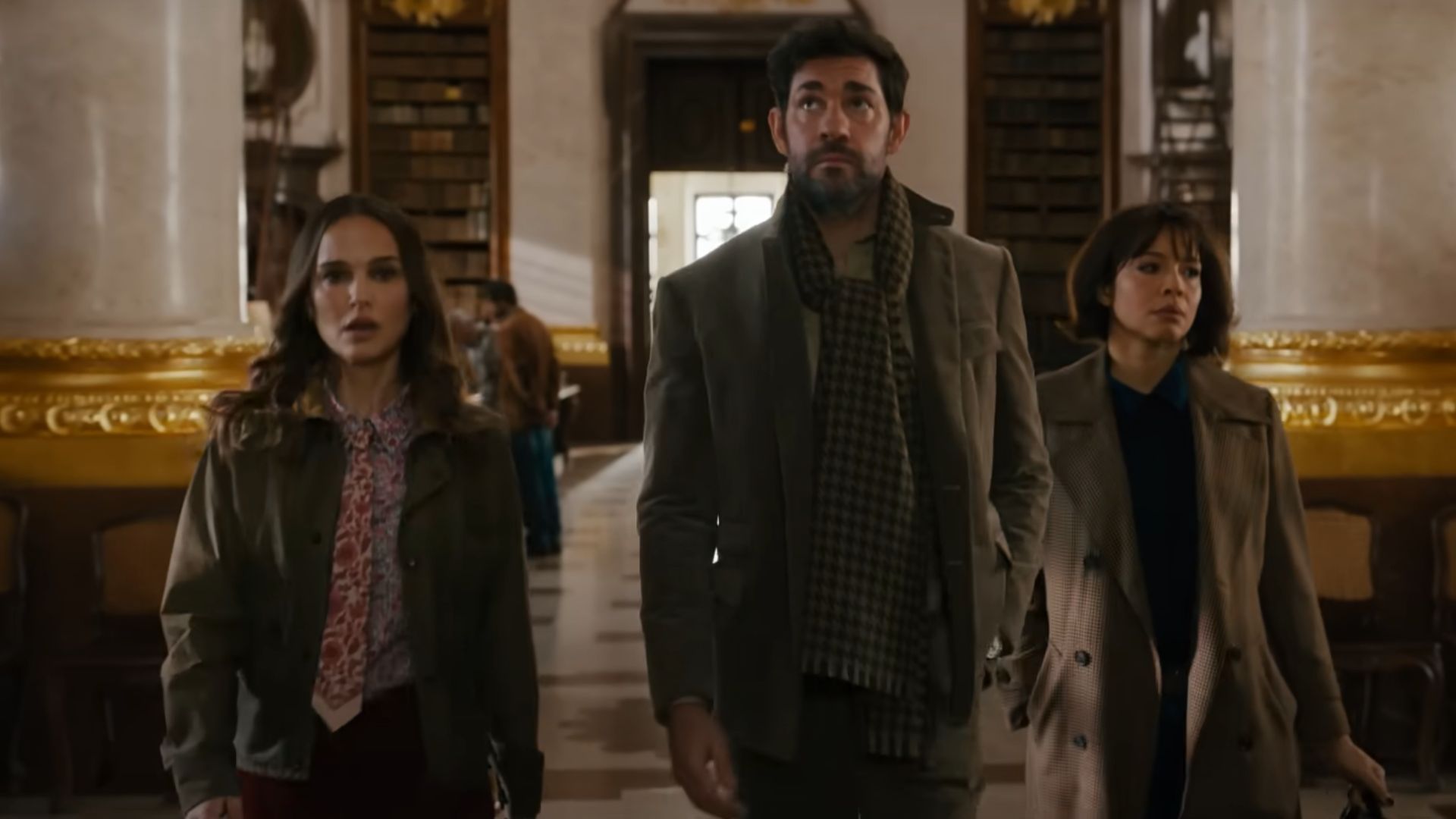 Three persons walking in a museum