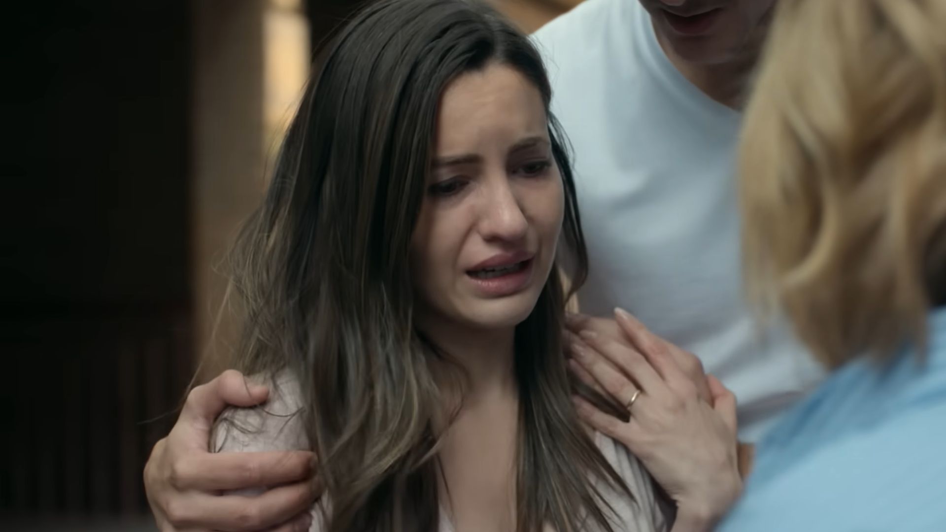 A woman sobbing and a man comforting her