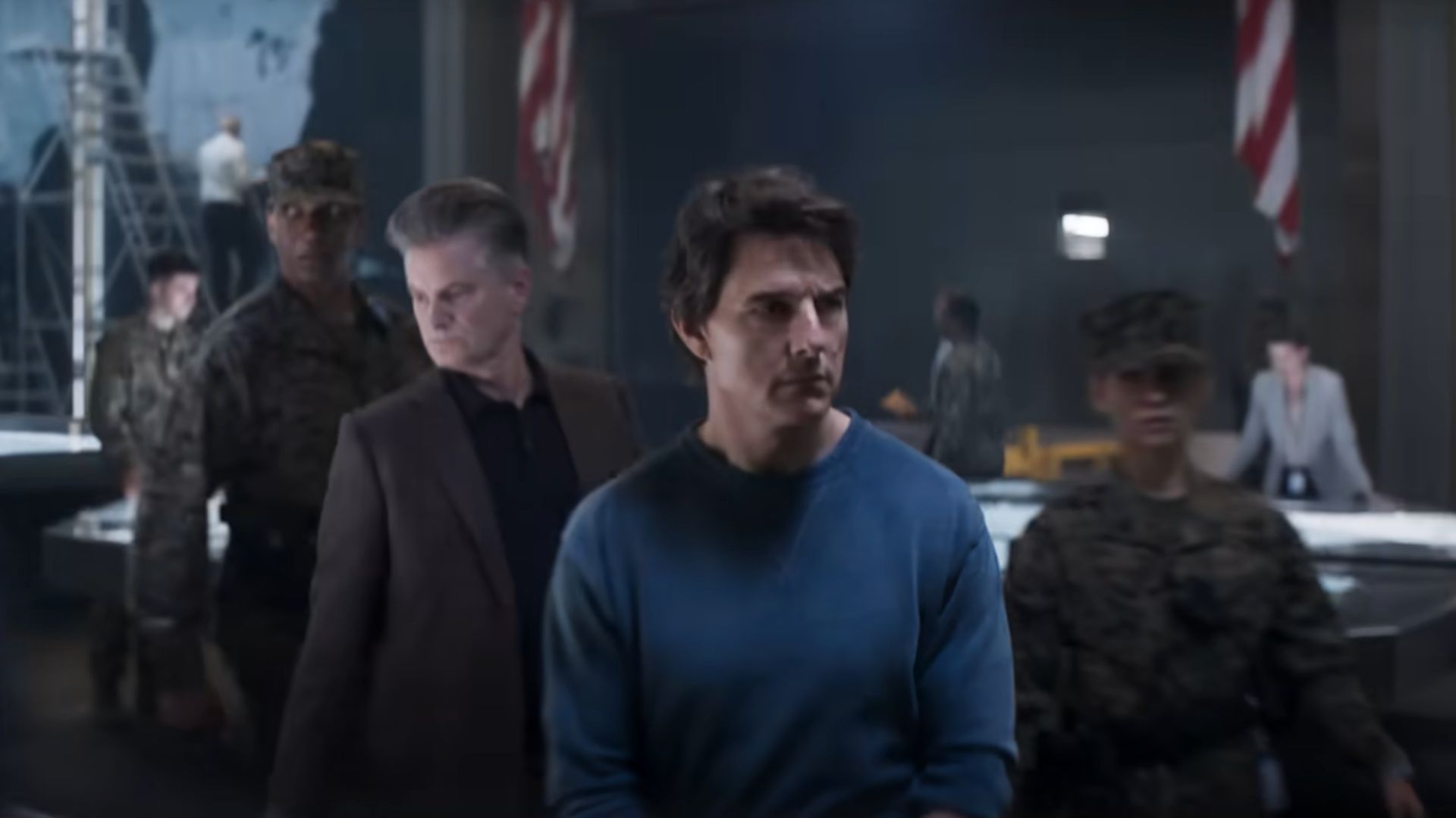 Ethan Hunt in handcuffs being escorted by government officials