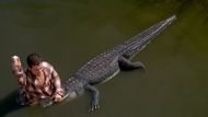 Happy successfully takes his golf ball back from the mouth of the alligator. (Image via Universal Pictures)