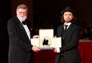 Holst (left) presenting the award. (Image via Getty)