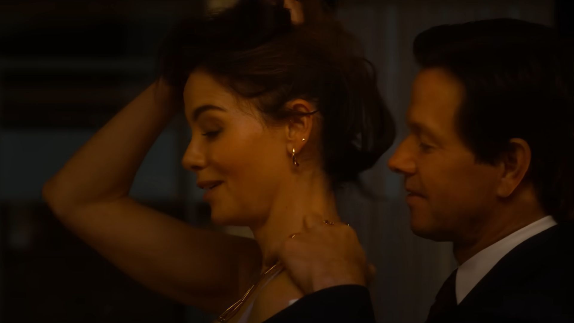Dan (Wahlberg) is putting a necklace on his wife