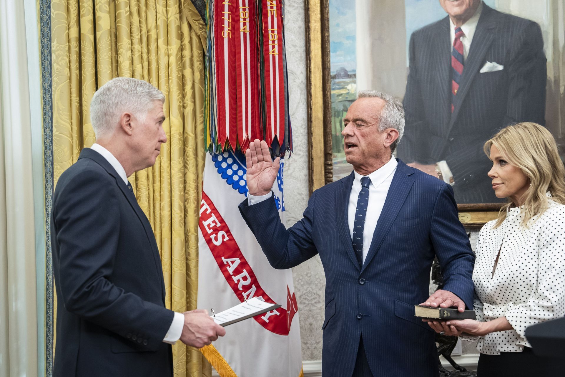 Robert F. Kennedy Jr. is flanked by Cheryl Hines as he is sworn in as the Health and Human Services Secretary, in the Oval Office at the White House in February 2025 (Image via Getty)