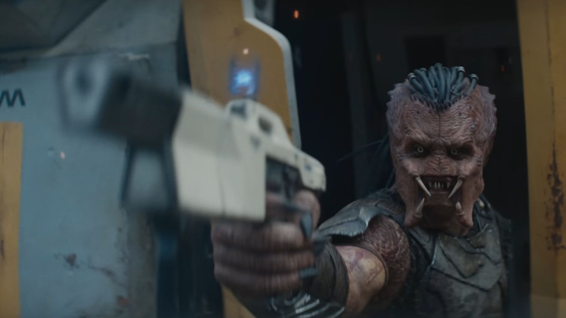 The young Predator holds a white gun pointing at someone