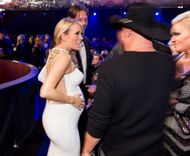 Carrie Underwood talking to Kenny Chesney as Mary Nolan looks on from the right (Image via Getty)
